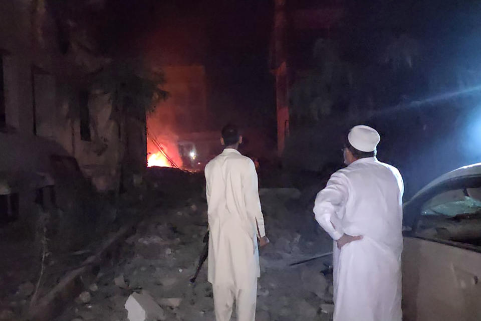 Plainclothes police officers gather at the site of a bomb explosion, in Kabal, an area of Pakistan's Swat Valley, Monday, April 24, 2023. Two explosions Monday at a counterterrorism police facility in northwest Pakistan killed few people and wounded dozens, police said. (AP Photo/Sherin Zara)