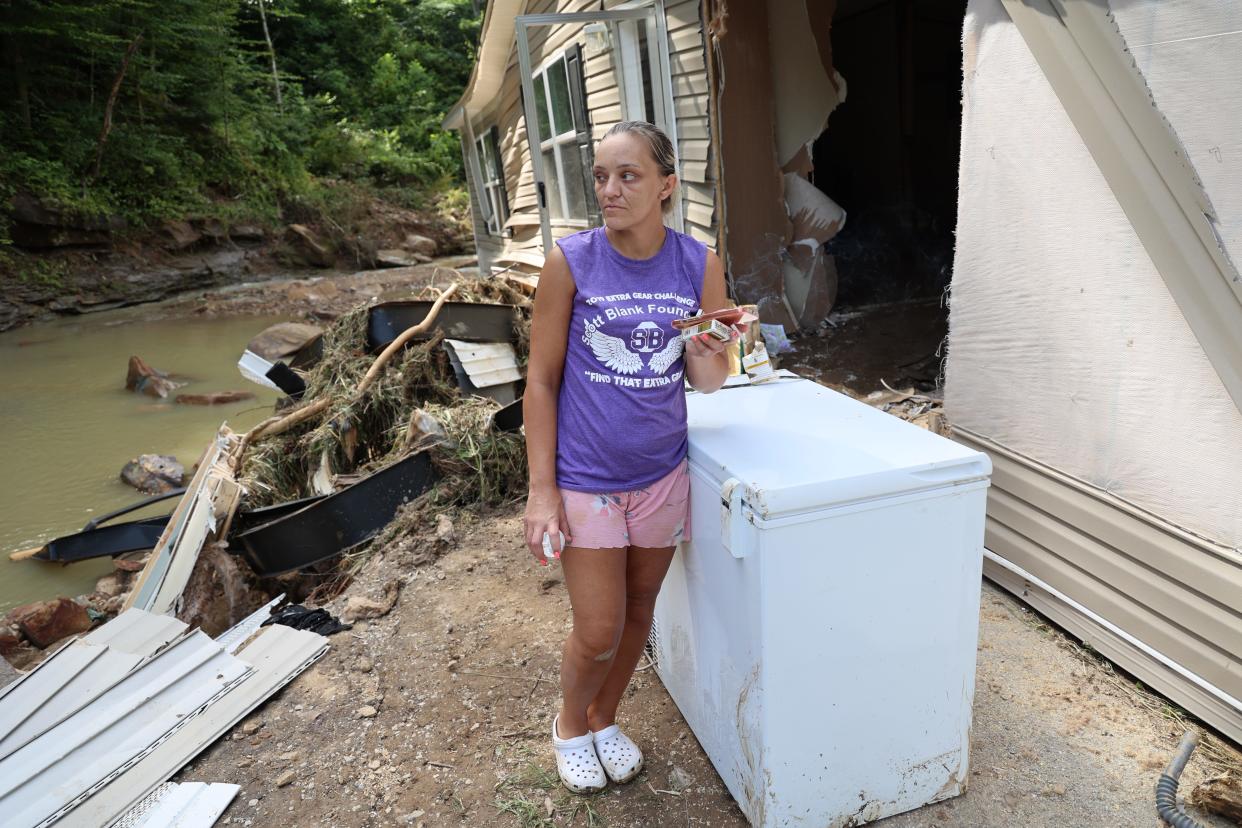 Jessica Willett, 34, of Breathitt County, Kentucky, stands next to her home that was ripped from its foundation in recent flooding while she was inside with her children.