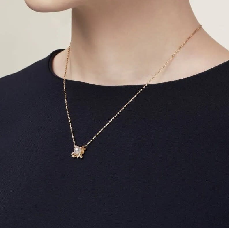 這款18K黃金與白珍珠的組合韻味十足又百搭，金屬墜飾設計靈感來自品牌字母M