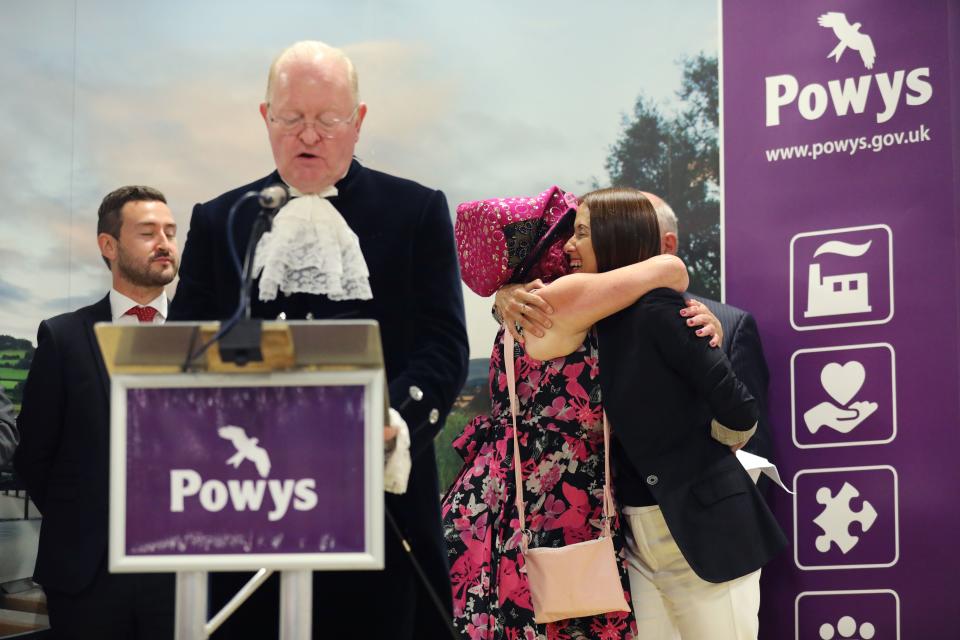 Liberal Democrat candidate Jane Dodds (R) is congratulated by the Official Monster Raving Loony Party candidate Lady Lily The Pink after winning the Brecon and Radnorshire by-election at the Royal Welsh Showground on August 2, 2019 in Builth Wells, Wales. - Britain's Boris Johnson lost his first major test as prime minister on August 2 when his candidate lost to a pro-EU rival in a by-election that could narrow his parliamentary majority to one. Official results showed the European-supporting Liberal Democrats' candidate Jane Dodds defeating Chris Davies from Johnson's ruling Conservative party by 13,826 to 12,401 votes. (Photo by Isabel INFANTES / AFP) / The erroneous mention appearing in the metadata of this photo by Isabel INFANTES has been modified in AFP systems in the following manner: [Jane Dodds] instead of [Jane Dodd]. Please immediately remove the erroneous mention from all your online services and delete it from your servers. If you have been authorized by AFP to distribute it to third parties, please ensure that the same actions are carried out by them. Failure to promptly comply with these instructions will entail liability on your part for any continued or post notification usage. Therefore we thank you very much for all your attention and prompt action. We are sorry for the inconvenience this notification may cause and remain at your disposal for any further information you may require.        (Photo credit should read ISABEL INFANTES/AFP/Getty Images)