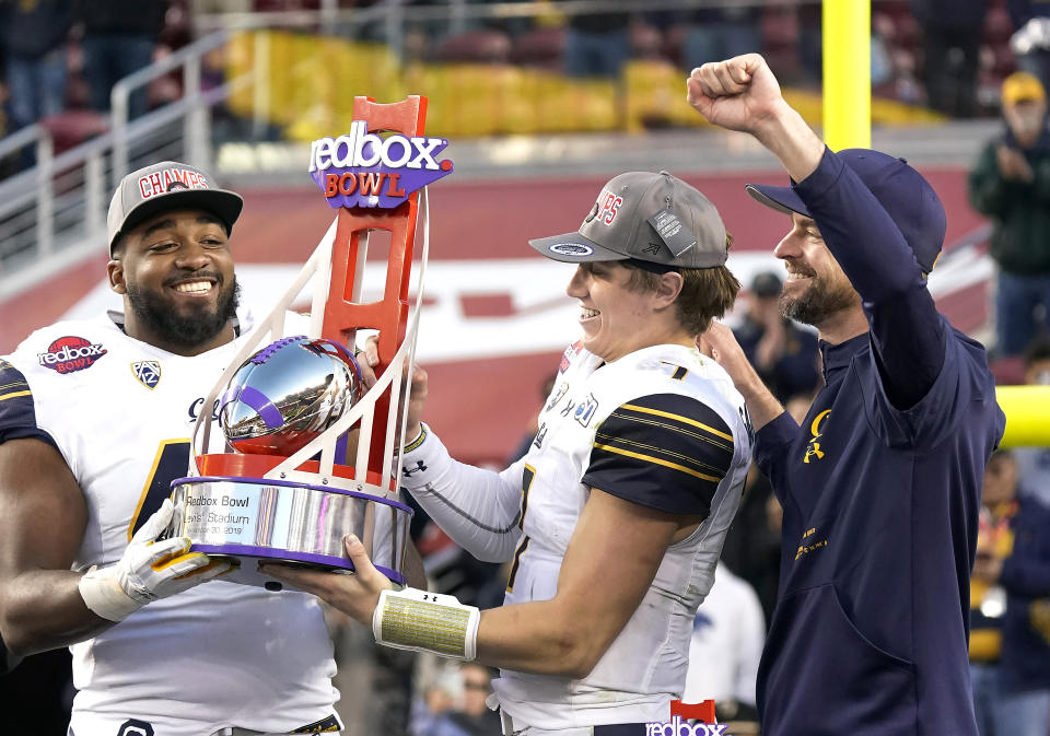 California defensive end Zeandae Johnson, left, quarterback Chase Garbers (7) and head coach Justin Wilcox, right, celebrate with the trophy after a win over Illinois in the Redbox Bowl NCAA college football game Monday, Dec. 30, 2019, in Santa Clara, Calif. (AP Photo/Tony Avelar)