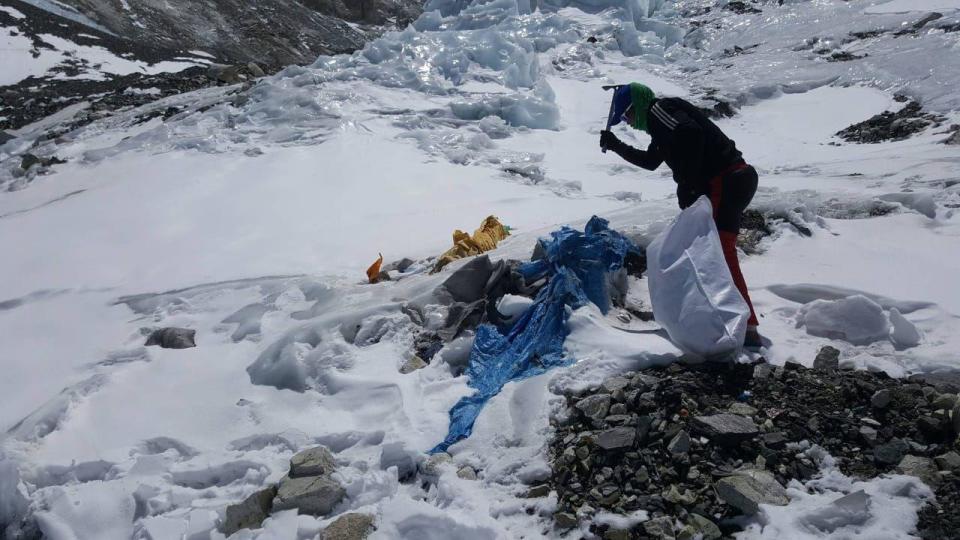 Un miembro de una campaña de limpieza que retira la basura que queda en el Campamento Tres.