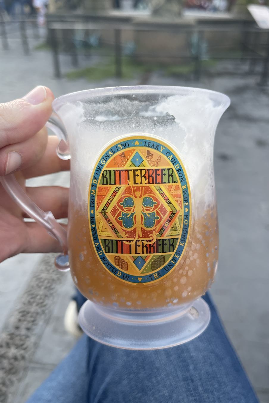 Hand holding a Butterbeer mug at the Wizarding World attraction