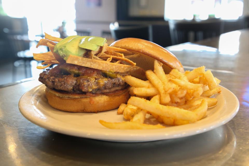 The Mexi Burger is Atomic Omelette and Grill's signature hamburger. It contains refried beans, Atomic salsa, cheddar cheese, tortilla strips, avocado and jalapeños.