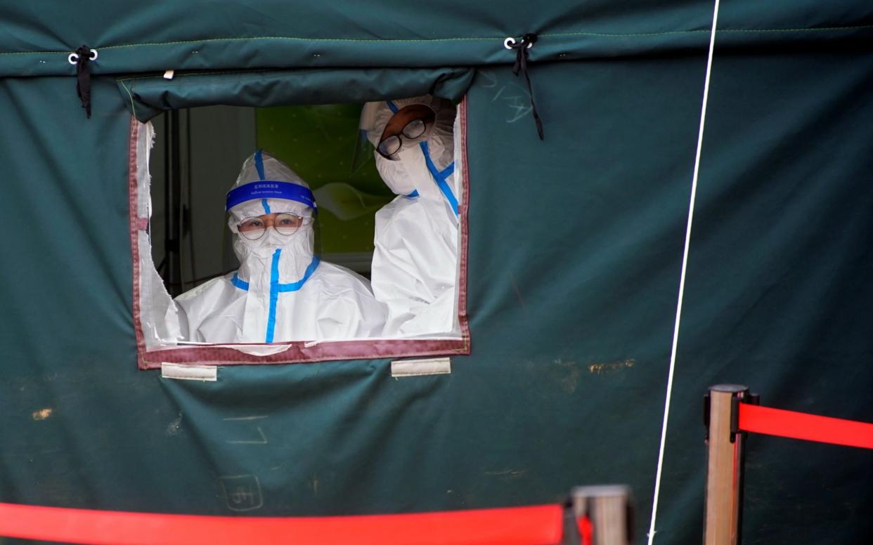 Medical workers in protective suits wait to collect swabs from rescue workers to test for Covid - Reuters