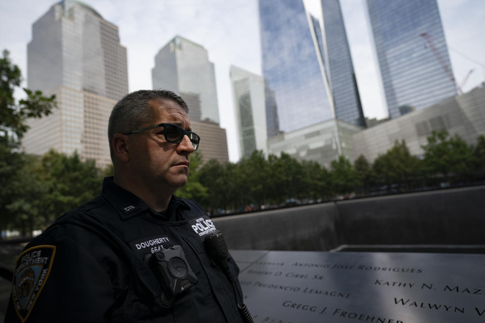 NYPD officer Michael Dougherty, a 25-year veteran, stands beside the south reflecting pool of the 9/11 Memorial & Museum where names of his deceased colleagues and friends are displayed, Monday, Aug. 16, 2021, in New York. Dougherty's first professional experience with the World Trade Center was as an electrician. "It's a privilege to be here," said Dougherty. "I'm at the end of my career and I couldn't think of a better place for me to finish up, connect where I started my career as an electrician over twenty five years ago before I became a police officer, and end up here. To be the guardian of this area and look over all my friends and family that passed away here 20 years ago." (AP Photo/John Minchillo)