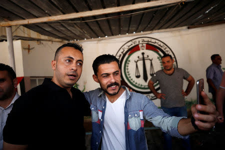 A Palestinian man takes a selfie with a member of Fatah movement upon his release from a Hamas-run jail as part of reconciliation efforts, in Gaza City October 1, 2017. REUTERS/Mohammed Salem