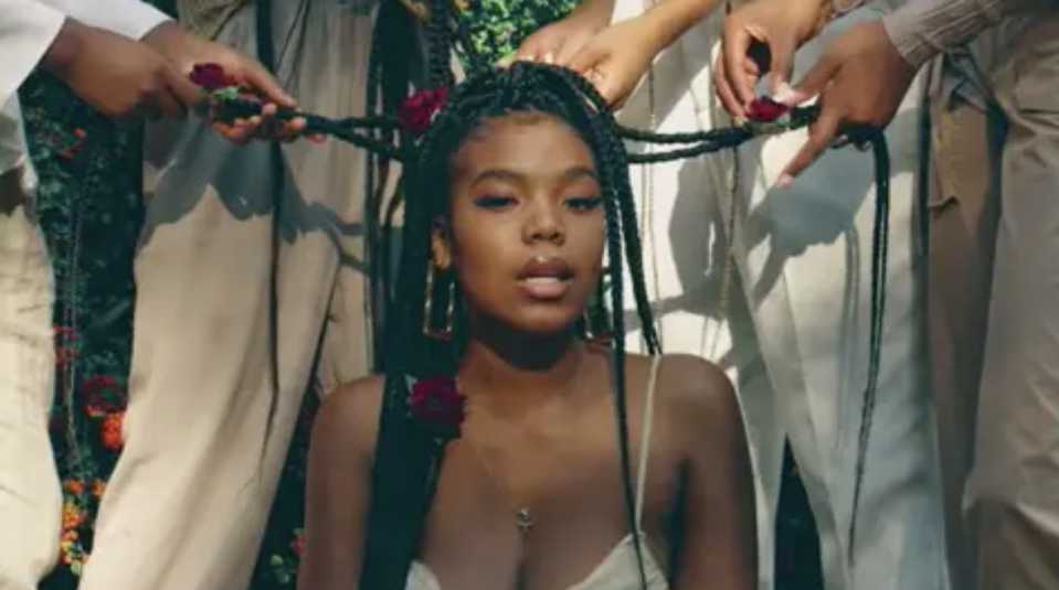 several hands touching a woman's braids