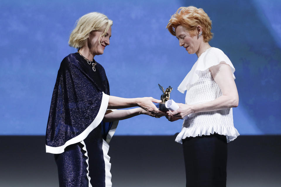 Actress Tilda Swinton, right, holds the Golden Lion for Lifetime Achievement presented by Jury President Cate Blanchett during the opening ceremony of the 77th edition of the Venice Film Festival in Venice, Italy, Wednesday, Sept. 2, 2020. (AP Photo/Domenico Stinellis)