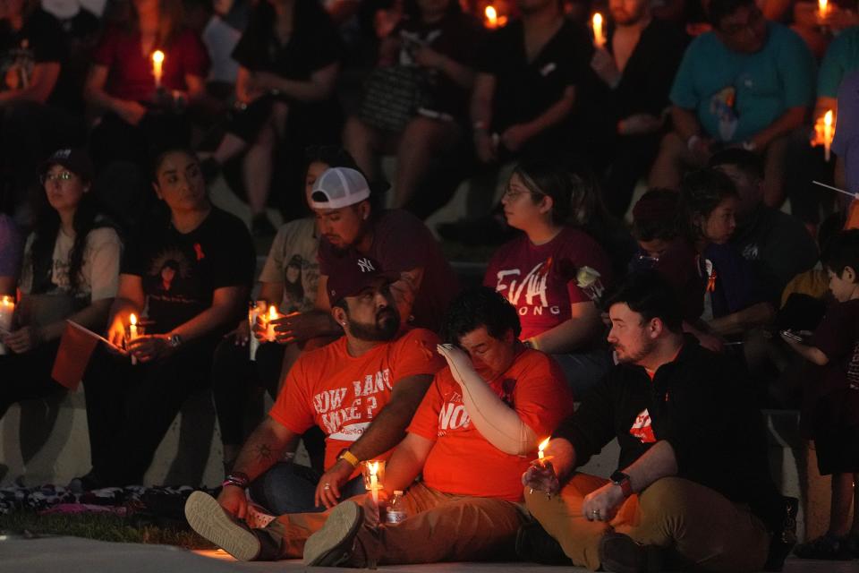 Reyes, bottom center, wipes tears from his face during a May 24, 2023, candlelight vigil in Uvalde for the shooting victims. All 11 students in his classroom were slain.