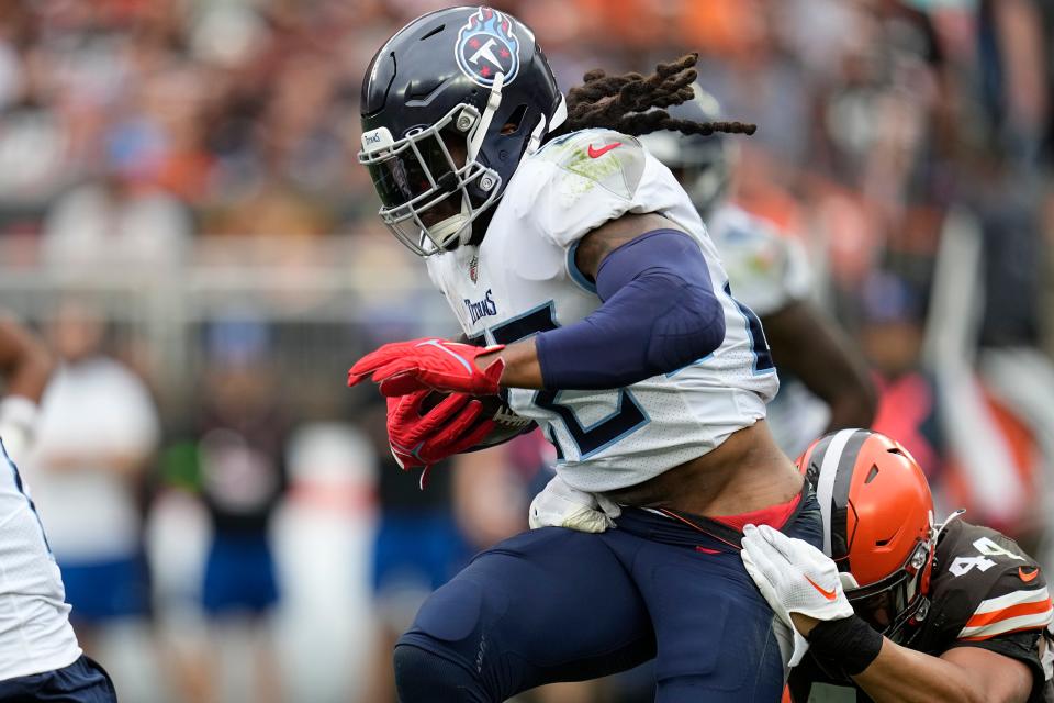 Tennessee Titans running back Derrick Henry, left, is tackled by Cleveland Browns linebacker Sione Takitaki, right, Sept. 24 in Cleveland.