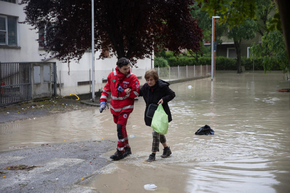 A member of the Italian Red Cross helps a resident evacuate after the flooding of the Savio river, in Cesena, on May 16.<span class="copyright">Max Cavallari—EPA-EFE/Shutterstock</span>