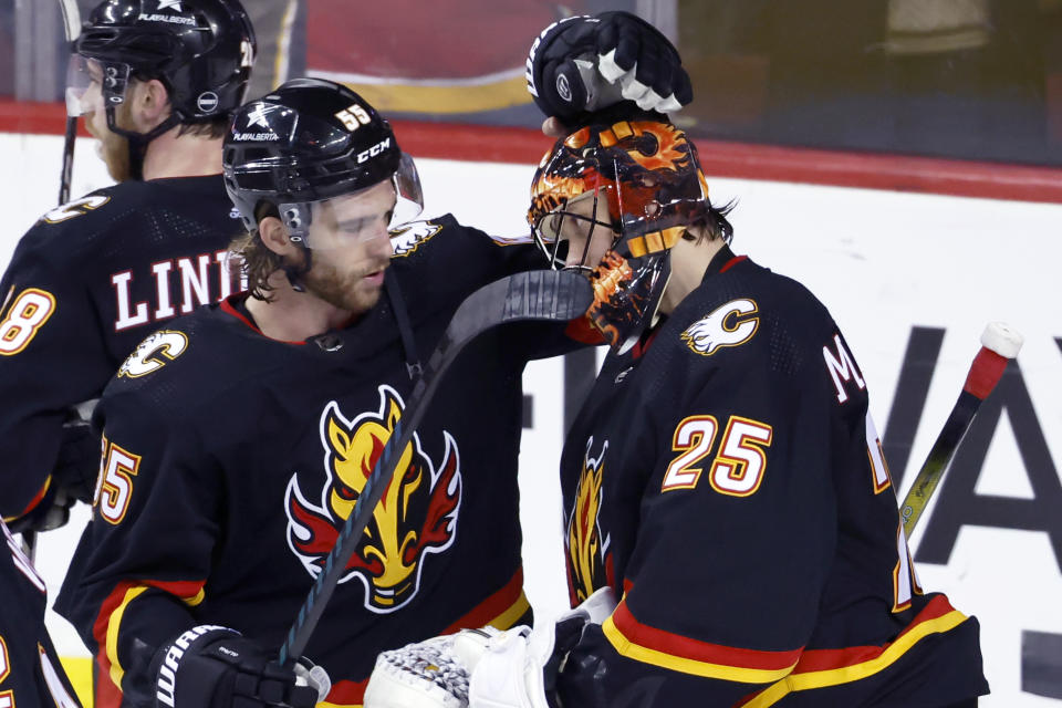 Calgary Flames goalie Jacob Markstrom celebrates with Noah Hanifin after the team's win over the Chicago Blackhawks in an NHL hockey game Saturday, Jan. 27, 2024, in Calgary, Alberta. (Larry MacDougal/The Canadian Press via AP)