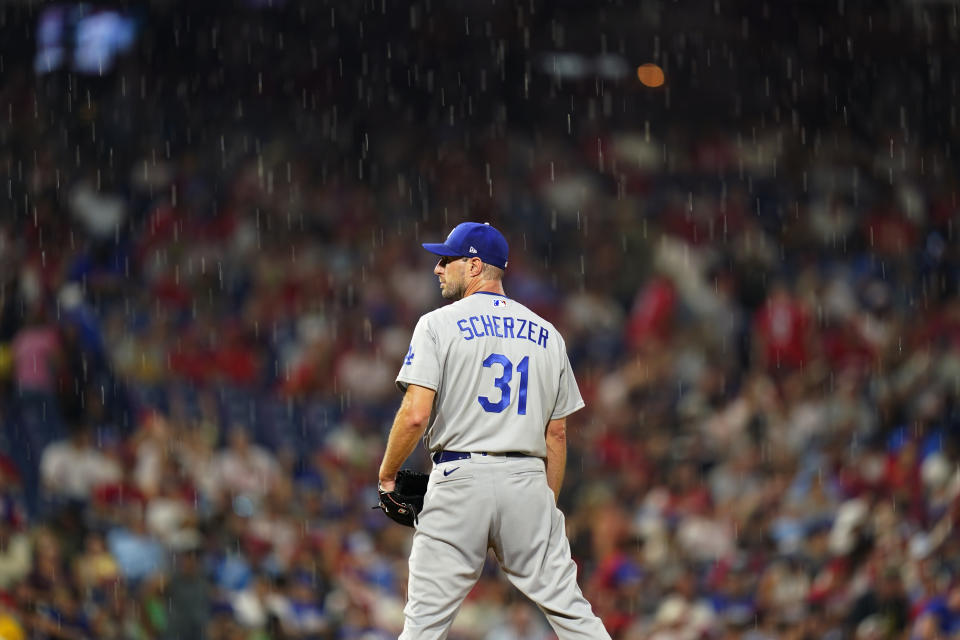 Los Angeles Dodgers starting pitcher Max Scherzer stands in the rain during the fourth inning of a baseball game against the Philadelphia Phillies, Tuesday, Aug. 10, 2021, in Philadelphia. (AP Photo/Matt Slocum)