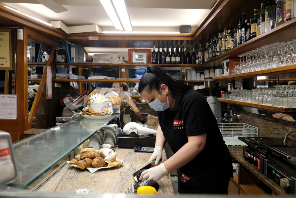 Staff prepare to welcome customers at a cafe in Venice.