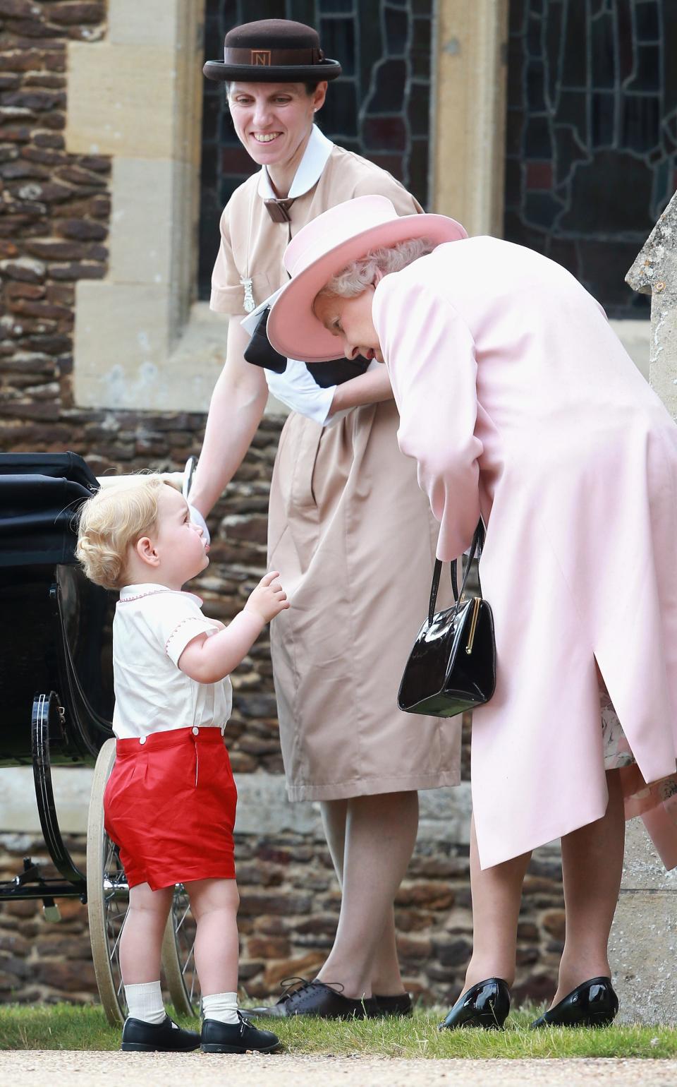 Queen Elizabeth bends down to talk to Prince George at Princess Charlotte's christening