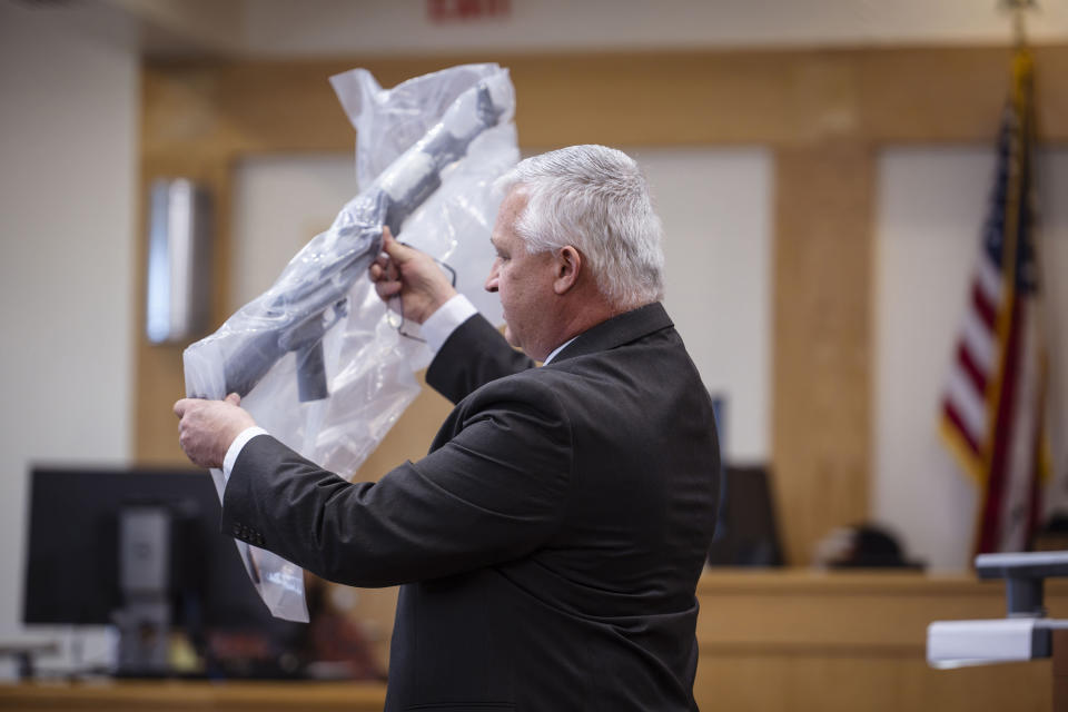 Prosecutor David Waymire shows the jury a AK-47 allegedly found in Muhammad Syed's possession, during opening statements in the trial of Syed at the Bernalillo County Courthouse in Downtown Albuquerque, N.M,, on Tuesday, March 12, 2024. Syed, an Afghan refugee, is accused in the slayings of three Muslim men in Albuquerque. (Chancey Bush/The Albuquerque Journal via AP, Pool)