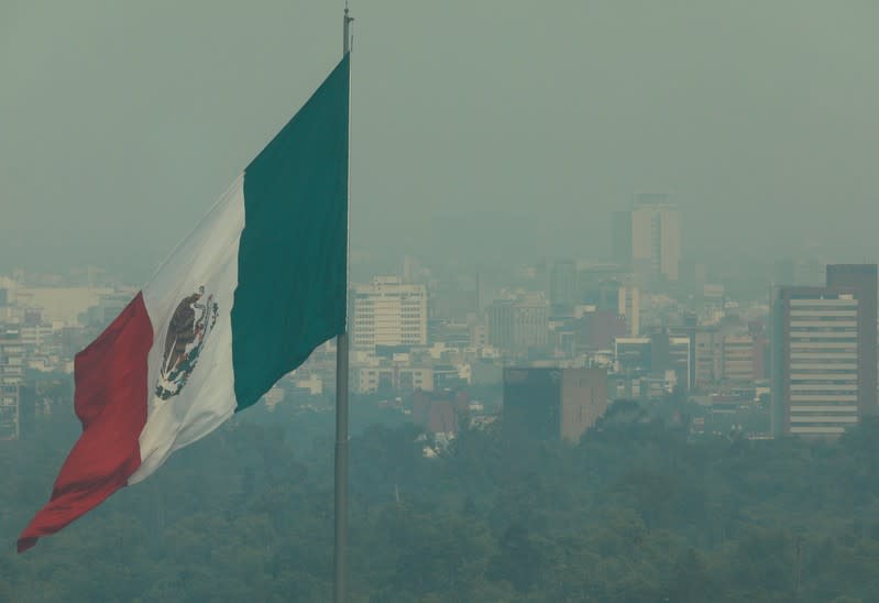 Foto de archivo. Una bandera mexicana frente a los edificios en Ciudad de México.