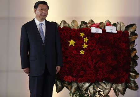 China's President Xi Jinping stands next to a flower arrangement depicting China's national flag during a ceremony at the National Pantheon in Caracas July 20, 2014. REUTERS/Carlos Garcia Rawlins