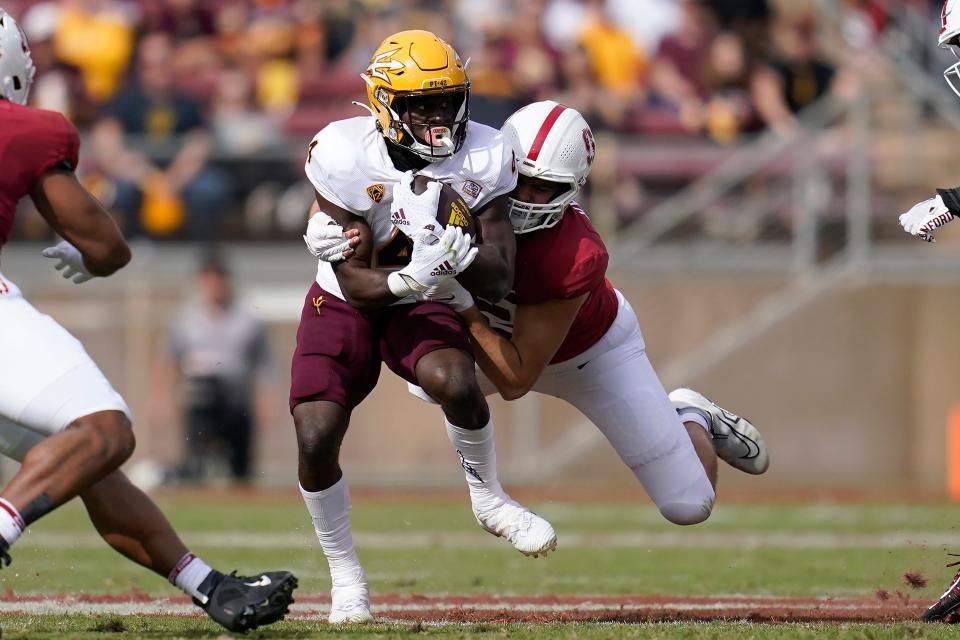 Arizona State running back Daniyel Ngata, center left, runs against Stanford defensive end Lance Keneley during the first half of an NCAA college football game in Stanford, Calif., Saturday, Oct. 22, 2022. (AP Photo/Jeff Chiu)