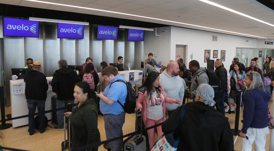 Passengers line up at the check-in counter for Avelo Airlines' first flight from Wilmington to San Juan, Puerto Rico, on Wednesday, Nov. 15, 2023.