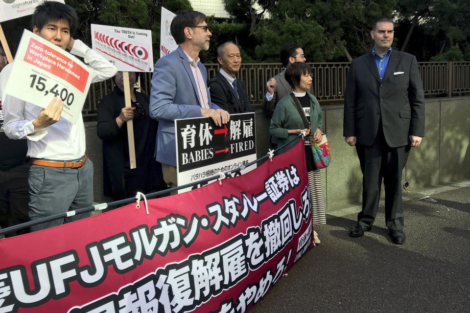 FILE - In this Oct. 9, 2019, file photo, former brokerage manager Canadian Glen Wood, right, arrives at the Tokyo District Court as he meets with his supporters before a hearing of the case that he was forced from his job for taking paternity leave in Tokyo. A Japanese court has rejected the demand by Wood to get his job back after he took paternity leave at Mitsubishi UFJ Morgan Stanley. (AP Photo/Yuri Kageyama, File)