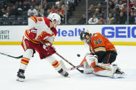 Anaheim Ducks goaltender John Gibson, right, makes a save against Calgary Flames' Matthew Tkachuk during the first period of an NHL hockey game Friday, Dec. 3, 2021, in Anaheim, Calif. (AP Photo/Jae C. Hong)