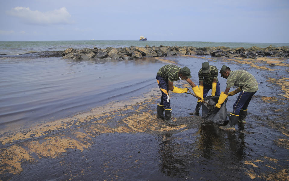 Sri Lankan army soldiers remove oil slick and sand from a beach following an oil spill in Uswetakeiyawa, a coastal town north of Colombo, Sri Lanka, Monday, Sept. 10, 2019.Sri Lanka deployed hundreds of coast guard and navy personnel on Monday to clean oil slicks on a coastal stretch near the capital following a spill caused by a pipeline leak. (AP Photo/Eranga Jayawardena)