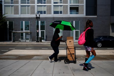 People walk in the Shaw neighbourhood during a heat wave in Washington