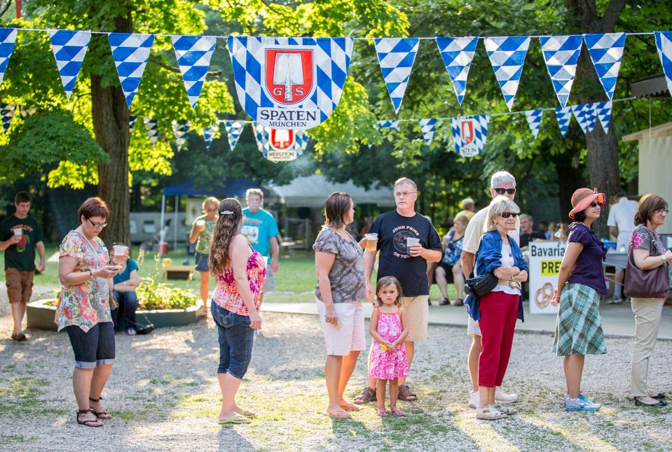 People line up to get food and drinks during the annual Bratfest held by the Peoria German American Society at Hickory Grove Park on Sunday afternoon.