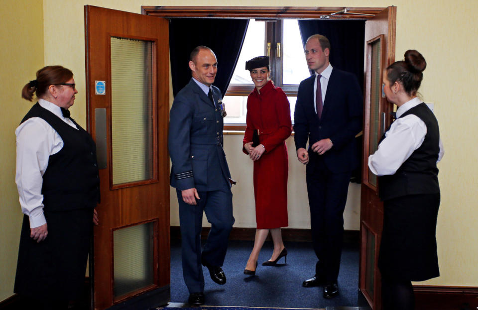 The Duchess of Cambridge in a bright red coat with her husband at a reception following a ceremony marking the end of RAF Search and Rescue (SAR) Force operations in Wales. 