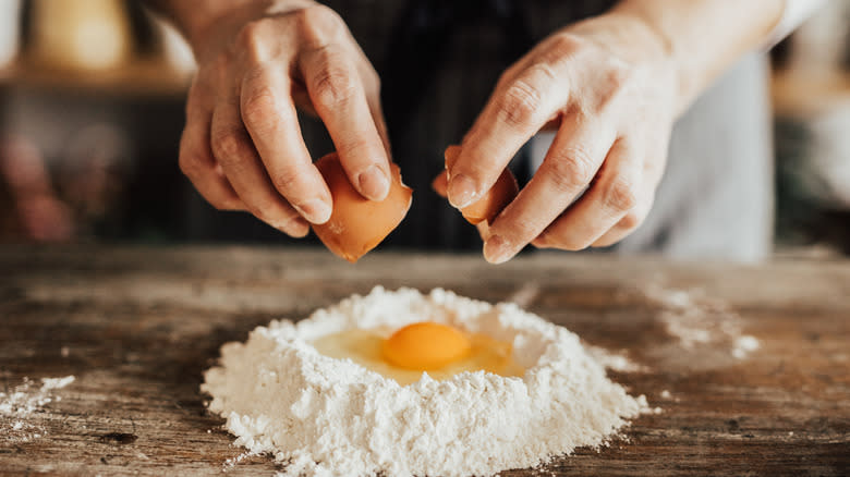 Cracking egg into flour