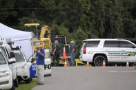 A Sarasota County Sheriff's Office deputy and a Sarasota County worker direct a truck carrying excavating equipment into the Carlton Reserve during a search for Brian Laundrie, Tuesday, Sept. 21, 2021, in Venice, Fla. Laundrie is a person of interest in the disappearance of his girlfriend, Gabrielle "Gabby" Petito. (AP Photo/Phelan M. Ebenhack)