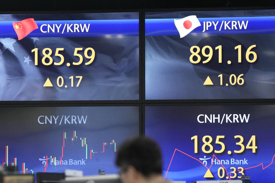 A currency trader walks by the screens showing the foreign exchange rates at a foreign exchange dealing room in Seoul, South Korea, Wednesday, March 6, 2024. Asian stocks were mixed on Wednesday after tumbling Big Tech stocks dragged Wall Street to its worst day in three weeks. (AP Photo/Lee Jin-man)
