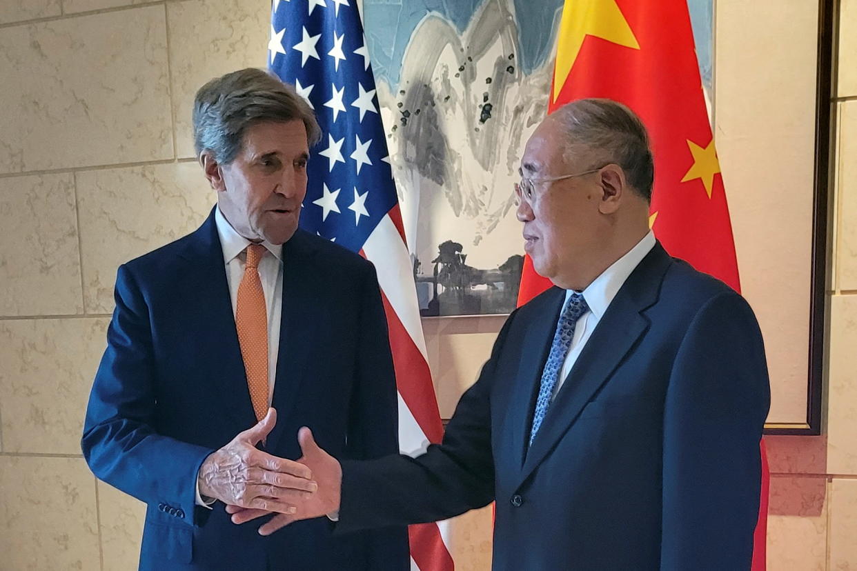 John Kerry shakes hands with Xie Zhenhua in front of U.S. and Chinese flags.