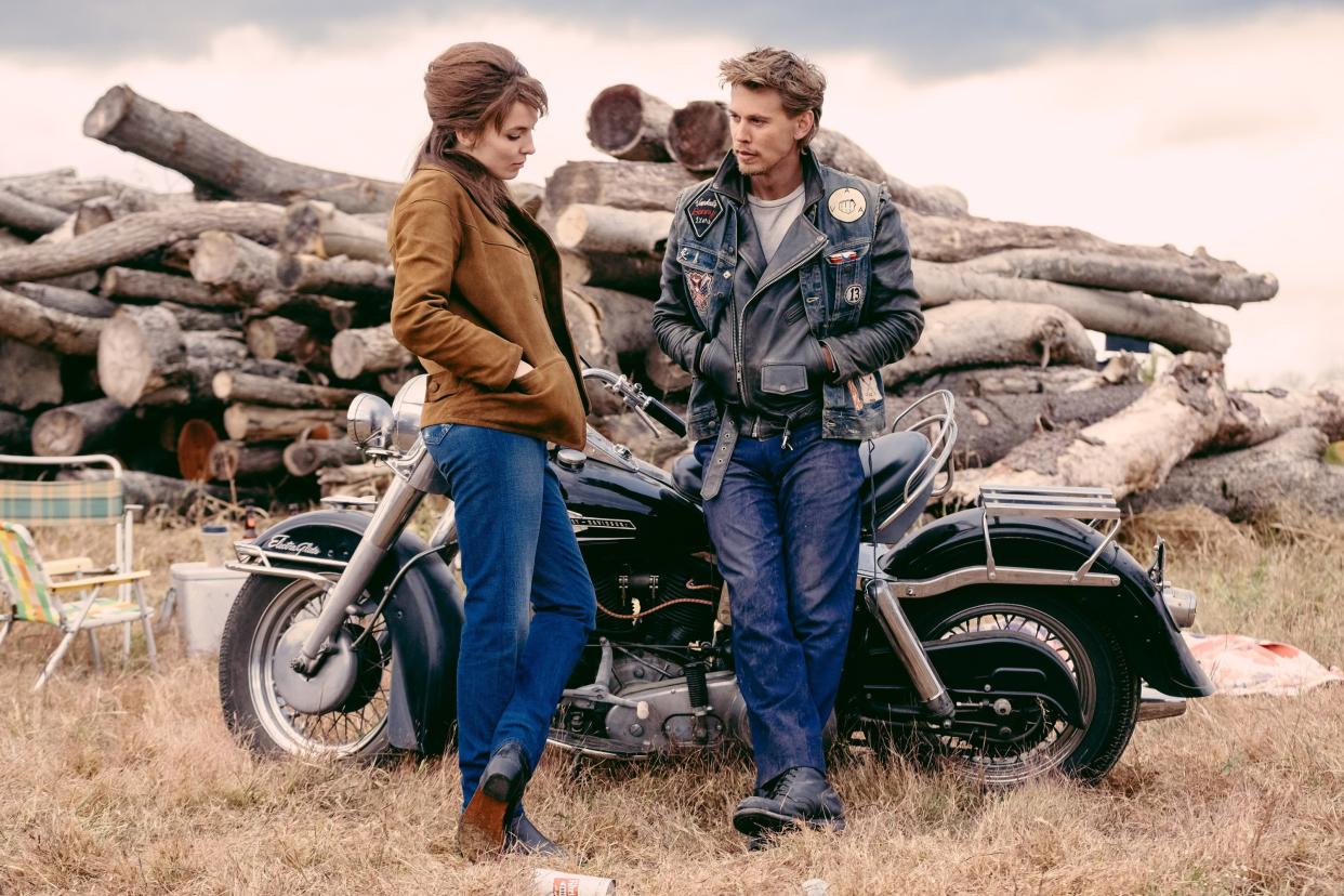 The actors Jodie Comer and Austin Butler stand next to a motorcycle in a scene from the movie.