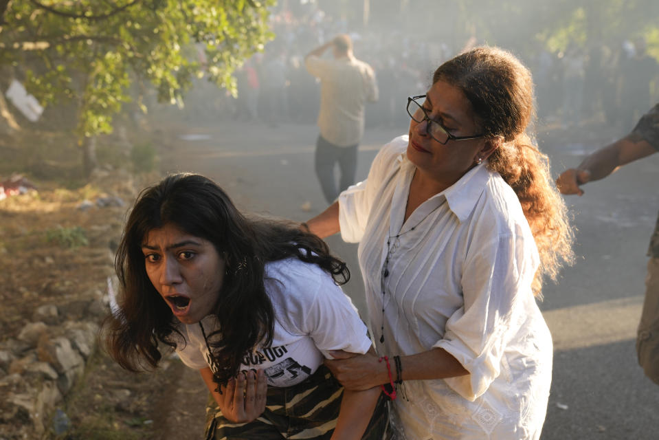 FILE - A Lebanese Armenian woman reacts to tear gas outside the Azerbaijani embassy in Beirut, Lebanon, on Thursday, Sept. 28, 2023. The swift fall of the Armenian-majority enclave of Nagorno-Karabakh to Azerbaijani troops and exodus of much of its population has stunned the large Armenian diaspora around the world. Hundreds of Lebanese Armenians on Thursday protested outside the Azerbajani Embassy in Beirut. They waved flags of Armenia and Nagorno-Karabakh and burned pictures of the Azerbaijani and Turkish presidents. Riot police lobbed tear gas when they threw firecrackers at the embassy. (AP Photo/Hussein Malla, File)