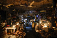 Vendors light candles at a market after a failure in Bangladesh's national power grid plunged much of the country into a blackout in Dhaka, Bangladesh, Tuesday, Oct.4, 2022. (AP Photo/Mahmud Hossain Opu)