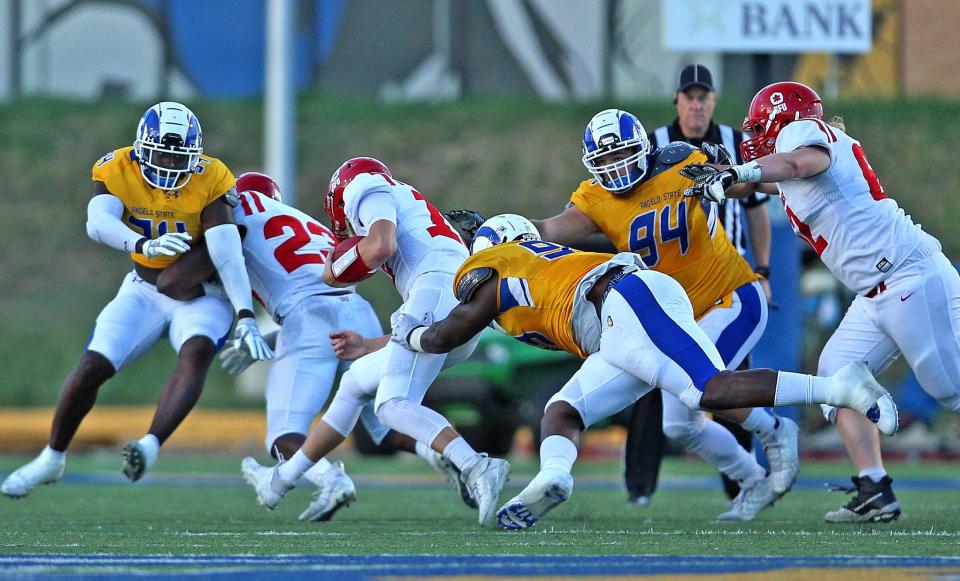 Tre'Darius Colbert, center, sacks the opposing quarterback for Angelo State University during a game against Simon Fraser on Saturday, Oct. 23, 2021.