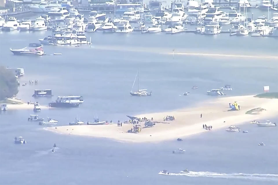 This image made from a video shows sand bank with crashed helicopter on Gold Coast, Australia Monday, Jan. 2, 2023. Two helicopters collided Monday afternoon over the Australian beach. (Australian Broadcasting Corp. via AP)