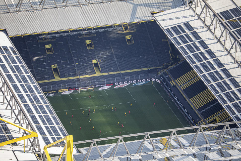 In this aerial image soccer players of both teams play the game in front of empty spectator stands during the German Bundesliga soccer match between Borussia Dortmund and FC Bayern Munich in Dortmund, Germany, Tuesday, May 26, 2020. The German Bundesliga is the world's first major soccer league to resume after a two-month suspension because of the coronavirus pandemic. (Marcel Kusch/DPA via AP, Pool)