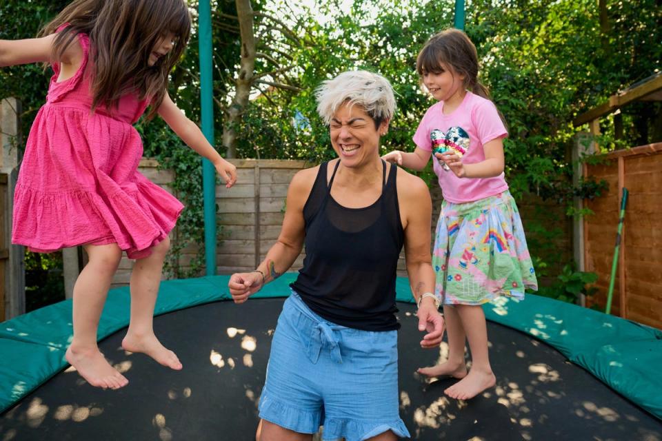 Mei-Ling and her daughters play on the trampoline at home (Cancer Research UK)