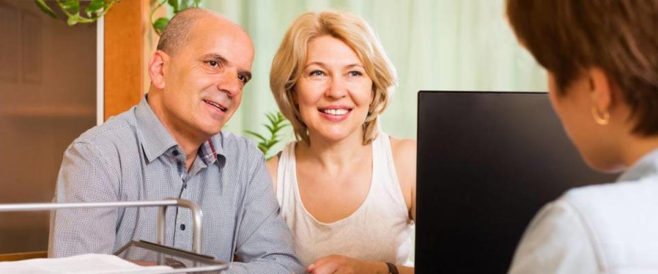 Positive senior couple opening saving account in bank