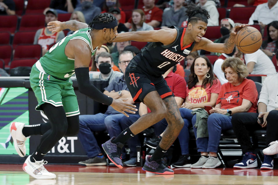 Houston Rockets guard Jalen Green (0) gets a ball before going out of bounds in front of Boston Celtics guard Marcus Smart, left, during the first half of an NBA basketball game Sunday, Oct. 24, 2021, in Houston. (AP Photo/Michael Wyke)