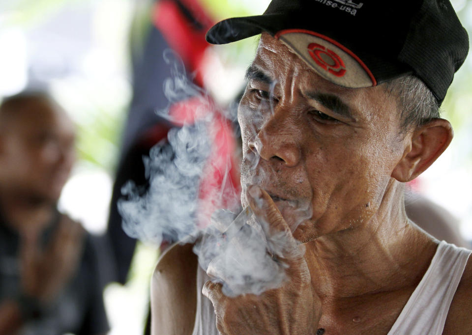 An Indonesian man smokes a cigarette in Jakarta, Indonesia, Tuesday, Sept. 11, 2012. Indonesian men rank as the world’s top smokers, with two out of three of them lighting up in a country where cigarettes cost pennies and tobacco advertising is everywhere. (AP Photo/Achmad Ibrahim)