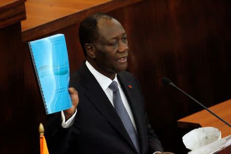 Ivory Coast's President Alassane Ouattara holds the new constitution project document during his speach at the Ivorian parliament in Abidjan October 5, 2016. REUTERS/Luc Gnago