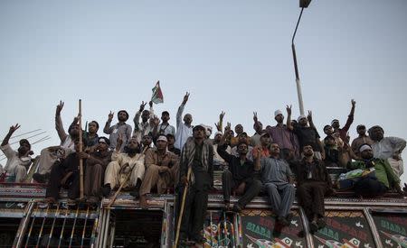 Supporters of Tahir ul-Qadri, Sufi cleric and leader of political party Pakistan Awami Tehreek (PAT), listen to their party leaders in front of the Parliament house building during the "Revolution March" in Islamabad August 27, 2014. Pakistani Prime Minister Nawaz Sharif told parliament on Wednesday he would not be cowed by thousands of demonstrators camped outside the assembly demanding his resignation. REUTERS/Zohra Bensemra