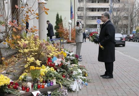 Ukraine's President Petro Poroshenko holds flowers near the French embassy as he commemorates victims of attacks in Paris, in Kiev, Ukraine, November 14, 2015. REUTERS/Valentyn Ogirenko