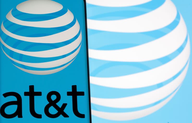 AT&T logo is seen on a smartphone in front of displayed same logo in this illustration