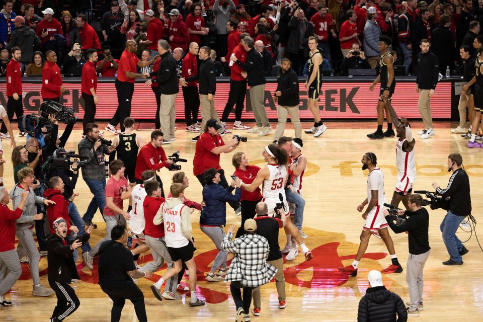 Nebraska men's basketball players celebrate with fans rushing onto the court following a 88-72 Big Ten Conference victory against Purdue on Jan. 9 in Lincoln, Neb. The Big Ten and ACC are the only two conferences among the six major basketball leagues that do not automatically fine host schools for allowing fans to storm the court.